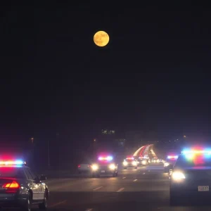 Police patrol cars in Chattanooga at night under a full moon